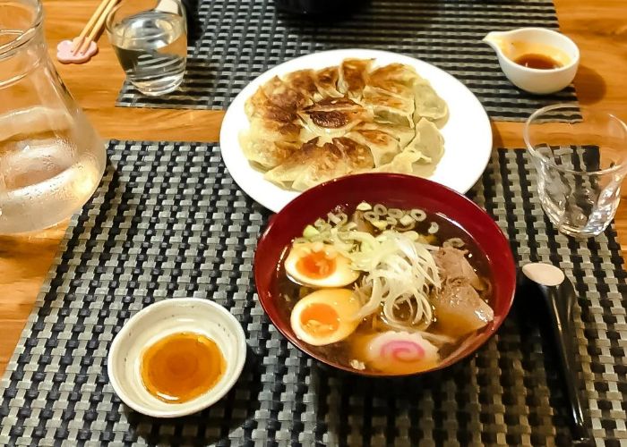A bowl of fresh ramen and a plate of gyoza at a cooking class in Japan.